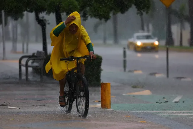 飓风西蒙逼近墨西哥太平洋沿岸,一名男子冒雨骑车